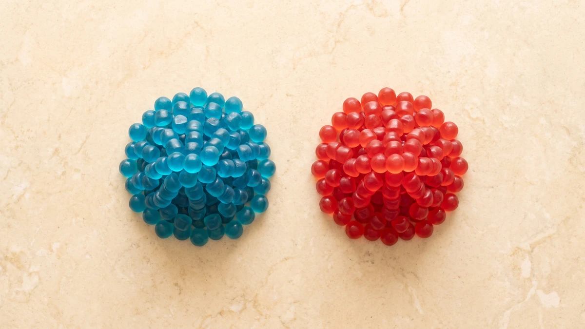 Overhead view of two equal piles of blue and red gummies
